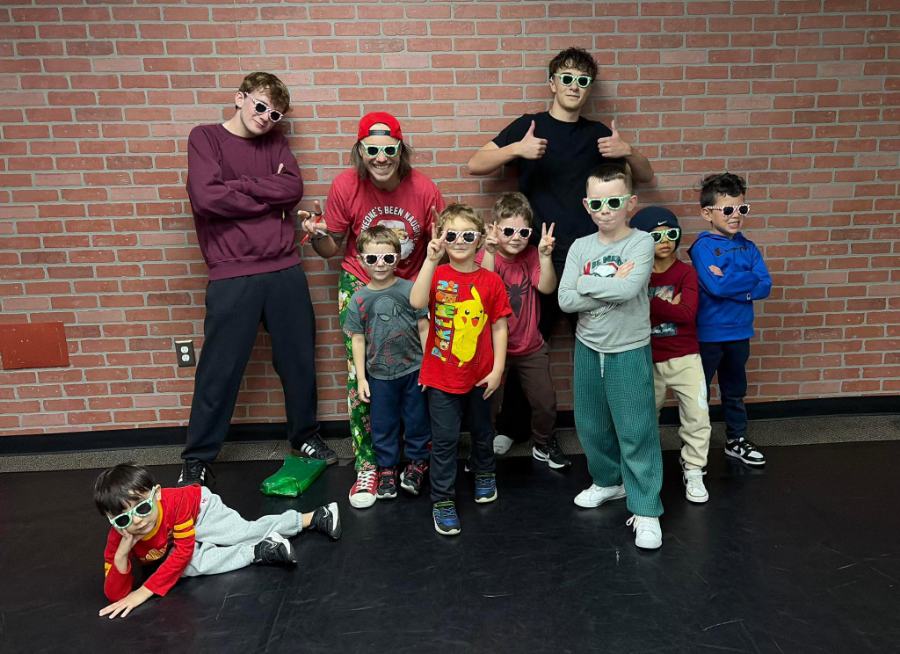 The boys class posing in matching sunglasses with their two teachers