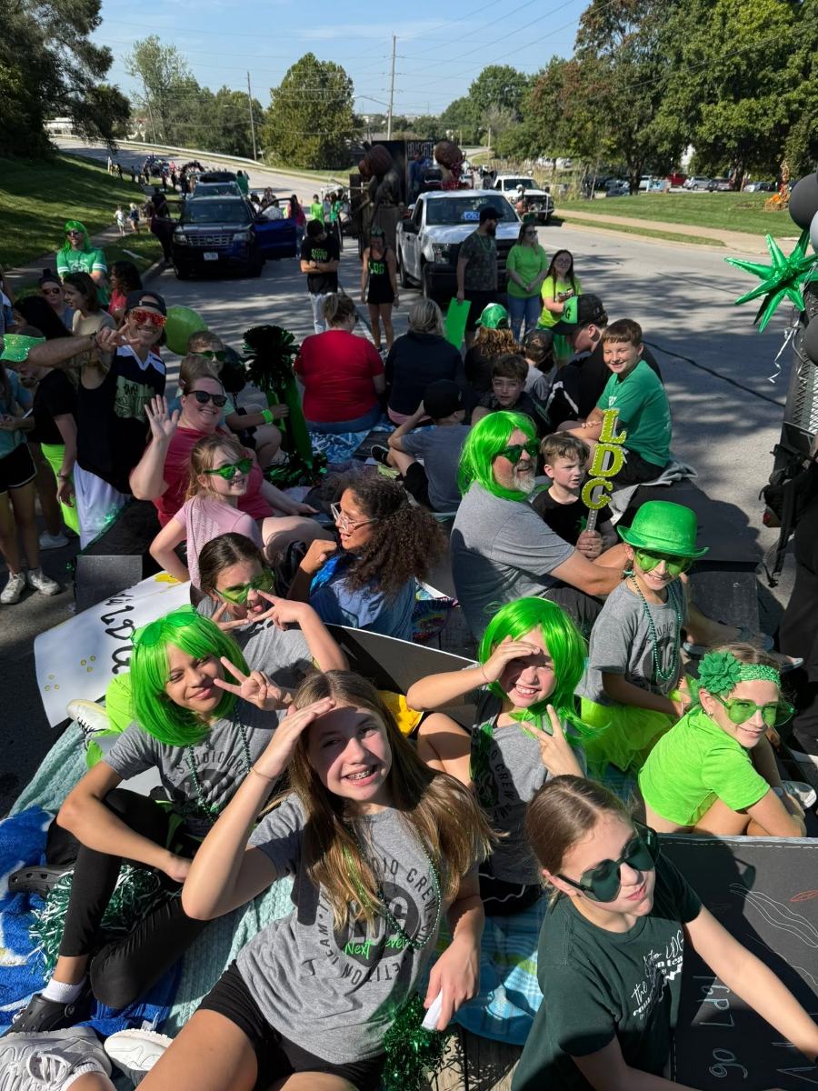 The LDG float in the Liberty parade, dancers and parents in bright green wigs and sunglasses